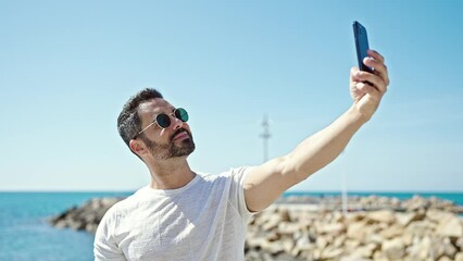 Sticker - Young hispanic man tourist smiling confident make selfie by smartphone at the beach