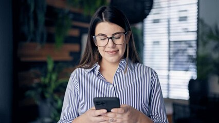 Poster - Young beautiful hispanic woman smiling happy using smartphone at the office