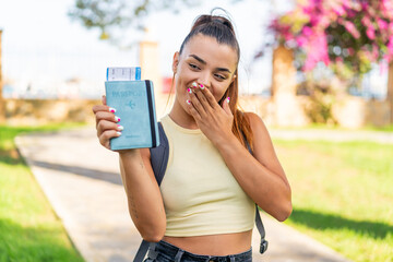 Wall Mural - Young pretty woman holding a passport at outdoors with surprise and shocked facial expression