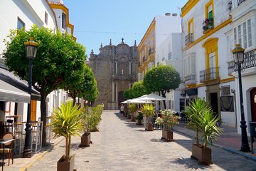 old town of Tarifa with typical white Andalusian houses, bars and restaurants and a view towards the Iglesia de San Mateo Apóstol, C. Sancho IV el Bravo, Costa de la Luz, Andalusia, Cádiz, Spain