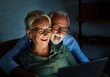 © Lumos sp - television watching couple laptop night computer home evening elderly senior mature active old woman man movie entertainment fun love together glowing screen