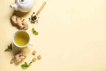 Cup of ginger tea with lemon and mint on yellow background