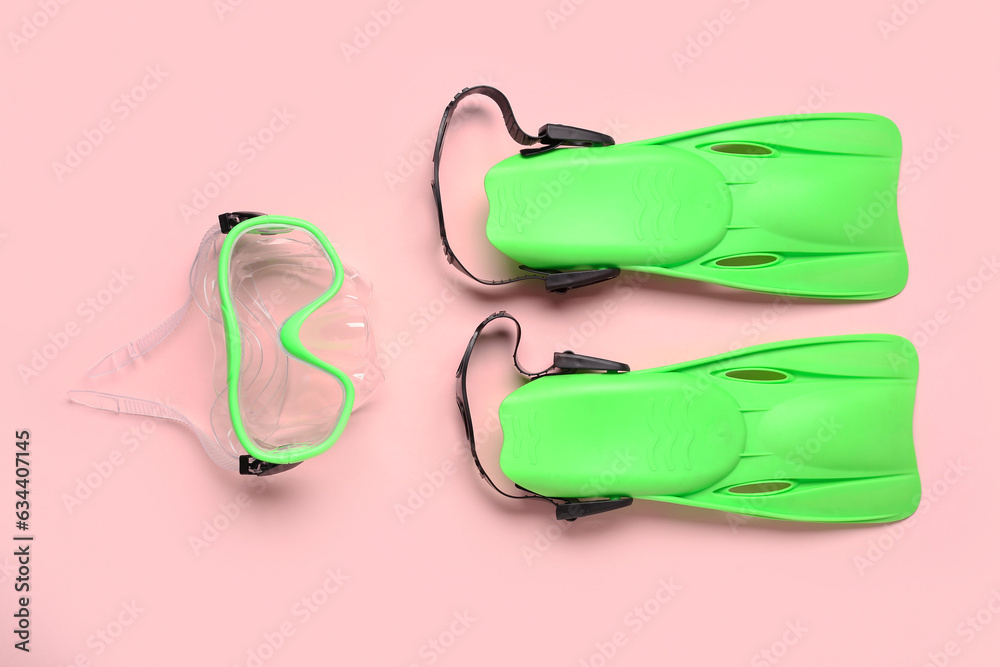 Swimming mask and flippers on pink background