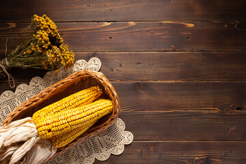 Wall Mural - Dried corn cob at wooden table as autumn still life