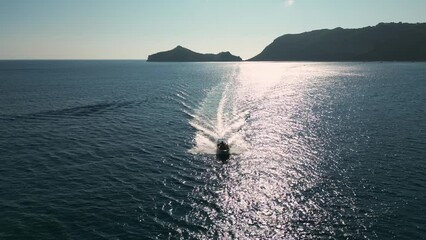 Wall Mural - A small motorboat cruises through the stunning turquoise waters of the Greek islands' serene sea