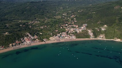 Wall Mural - Drone aerial footage of Agios Georgios Beach, featuring its turquoise waters and sandy shoreline, set against the charming backdrop of rolling hills