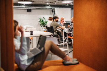 Poster - Team of inclusive workers having a brainstorm session with their disabled colleague at the office