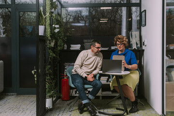 Middle-aged business partners working together at modern co working space