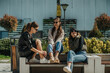 © qunica.com - Front view shot of three lovely girls sitting on a bench and having a fun conversation, on nice sunny day