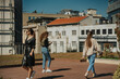 © qunica.com - Two lovely brunette girls walking and looking somewhere while their curly haired girl is looking at her phone