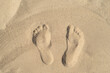Texture background footprints of human feet on the sand  on the beach