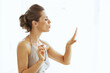 © Alliance - Young woman blowing on nails after applying nail polish in bathr