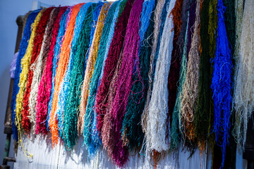 Woman is weaving beautiful carpet with Uzbekistan silk