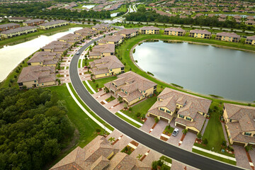 Wall Mural - Aerial view of tightly packed homes in Florida closed living clubs with lake water in the middle. Family houses as example of real estate development in american suburbs