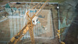 Yellow crane in construction site with graphics for production trend and control of workers team. Potential investiment income calculator. Aerial 