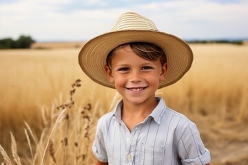 Wall Mural - Portrait of a cute little boy in a straw hat on a wheat field