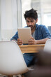 © Image Smith - Asian man sitting at a table reading a Tablet PC.