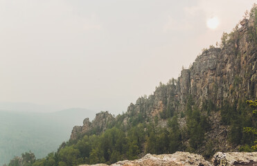 Rocks of Aigir in the smoke of a forest fire. Bashkortostan.