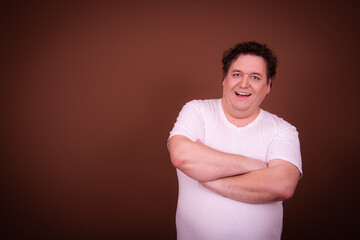 Wall Mural - Funny fat man posing on a brown background.