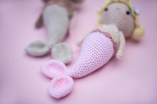 Close-up Of Two Crochet Amigurumi Mermaids On A Pink Background