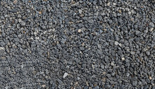Gray Small Rocks Ground Texture. Black Small Road Stone Background. Gravel Pebbles Stone Seamless Texture. Dark Background Of Crushed Granite Gravel, Close Up. Clumping Clay