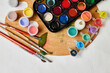 Flat lay of colorful paints, painting palette and brushes