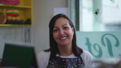 Wall Mural - Portrait of a happy female Entrepreneur owner of small business behind counter wearing apron