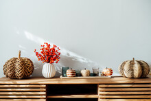 Cozy Autumn Home Interior - Various Decorative Wicker Pumpkins, Candles, Seasonal Flowers In Vase On The Wooden Console With White Wall Background. Scandinavian Minimalist Hygge Home Fall Decor.