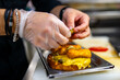 © pavel siamionov - chef hand cooking burger with vegetables and meat on restaurant kitchen