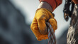 A close-up of a climber's gloved hand gripping a rope, showcasing the determination and effort required on the ascent 