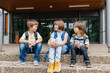 © Elena Medoks - Children sit on the steps of the school and talk. Schoolchildren rest during recess or after school and communicate with each other.
