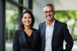 © wolfhound911 - Happy confident professional mature business man and business woman corporate leaders managers standing in office, two diverse colleagues executives team posing together, portrait