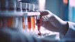 © redflower - Close-up of a doctor carefully handling a blood test tube in a clinical setting