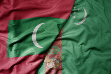 big waving realistic national colorful flag of maldives and national flag of turkmenistan .
