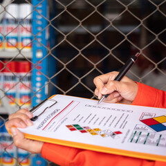 Wall Mural - a worker is checking on the hazardous chemical material information form with background of chemical