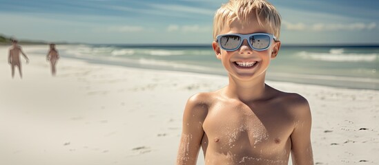 Wall Mural - A summertime greeting with a happy boy at the beach