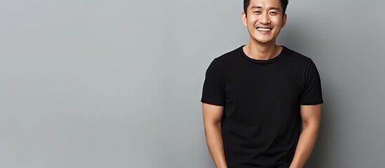 Aufkleber - Asian male smiling and holding a blank space dressed in black polo t shirt on white background