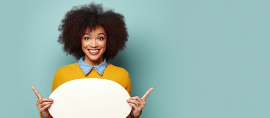Aufkleber - Excited African woman holding painter palette pointing aside with open palms showcasing copy space for advertisement with a joyful smile