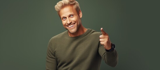 Poster - A cheerful and happy adult man with blond hair pointing upwards towards empty space