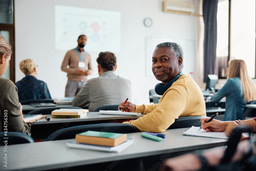 Mature black man attending educational seminar in lecture hall and ...