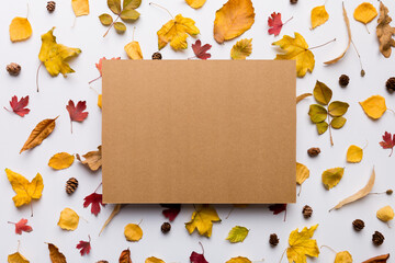 Wall Mural - autumn composition with paper blank and dried leaves on table. flat lay, top view, copy space