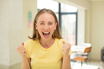 Canvas Print - pretty blond woman feeling shocked, excited and happy, laughing and celebrating success, saying wow!