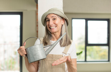 Wall Mural - pretty senior woman smiling cheerfully, feeling happy and showing a concept. gardener concept