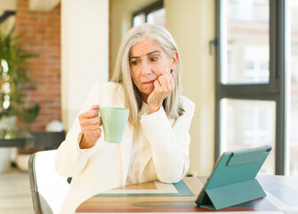 Sticker - senior pretty woman feeling scared, worried or angry and looking to the side with a touch screen