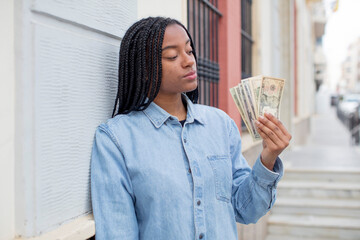 Wall Mural - black afro woman smiling and looking with a happy confident expression. dollar banknotes concept