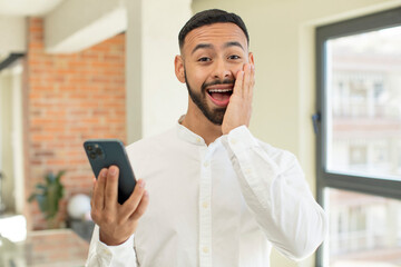 young  adult man feeling happy and astonished at something unbelievable. smartphone concept