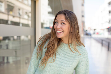 Wall Mural - pretty hispanic woman with a big, friendly, carefree smile, looking positive, relaxed and happy, chilling