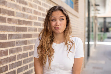 Wall Mural - pretty hispanic woman wondering, thinking happy thoughts and ideas, daydreaming, looking to copy space on side