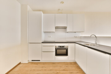 a kitchen with white cabinets and black counter tops on the island in front of the sink is not visible, but there is no