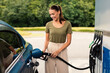 © Prostock-studio - Smiling Woman Refilling Auto with Fuel at Modern Petrol Station